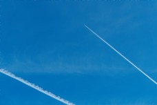 远山飞上云端的飞机在蓝天划出白线