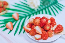 一盘草莓和勺子里的新鲜草莓
